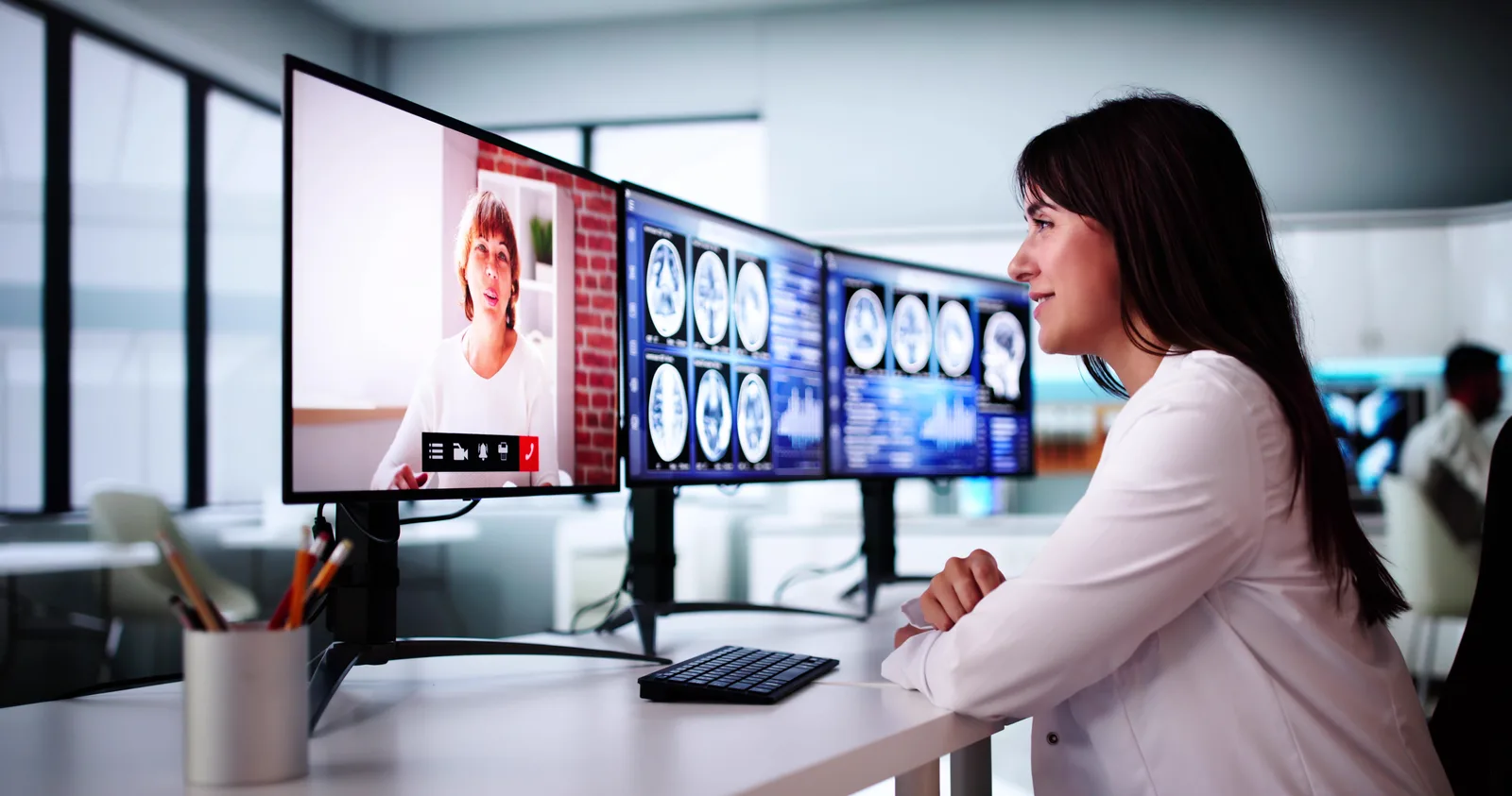 Female doctor performing telehealth visit with brain scans open